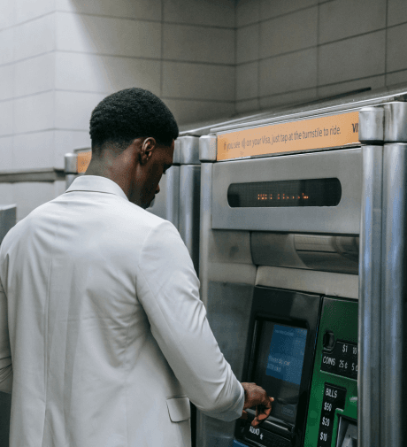 User operating HMI interface on a public transit fare machine