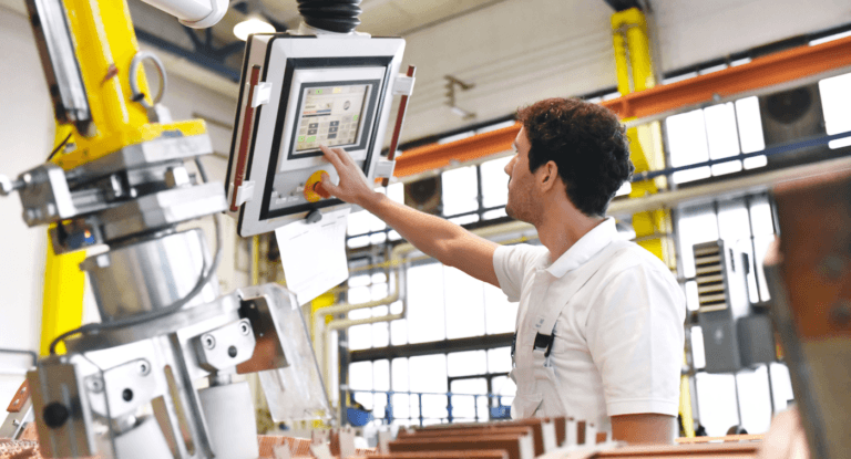 Technician using HMI control panel for managing industrial manufacturing machinery